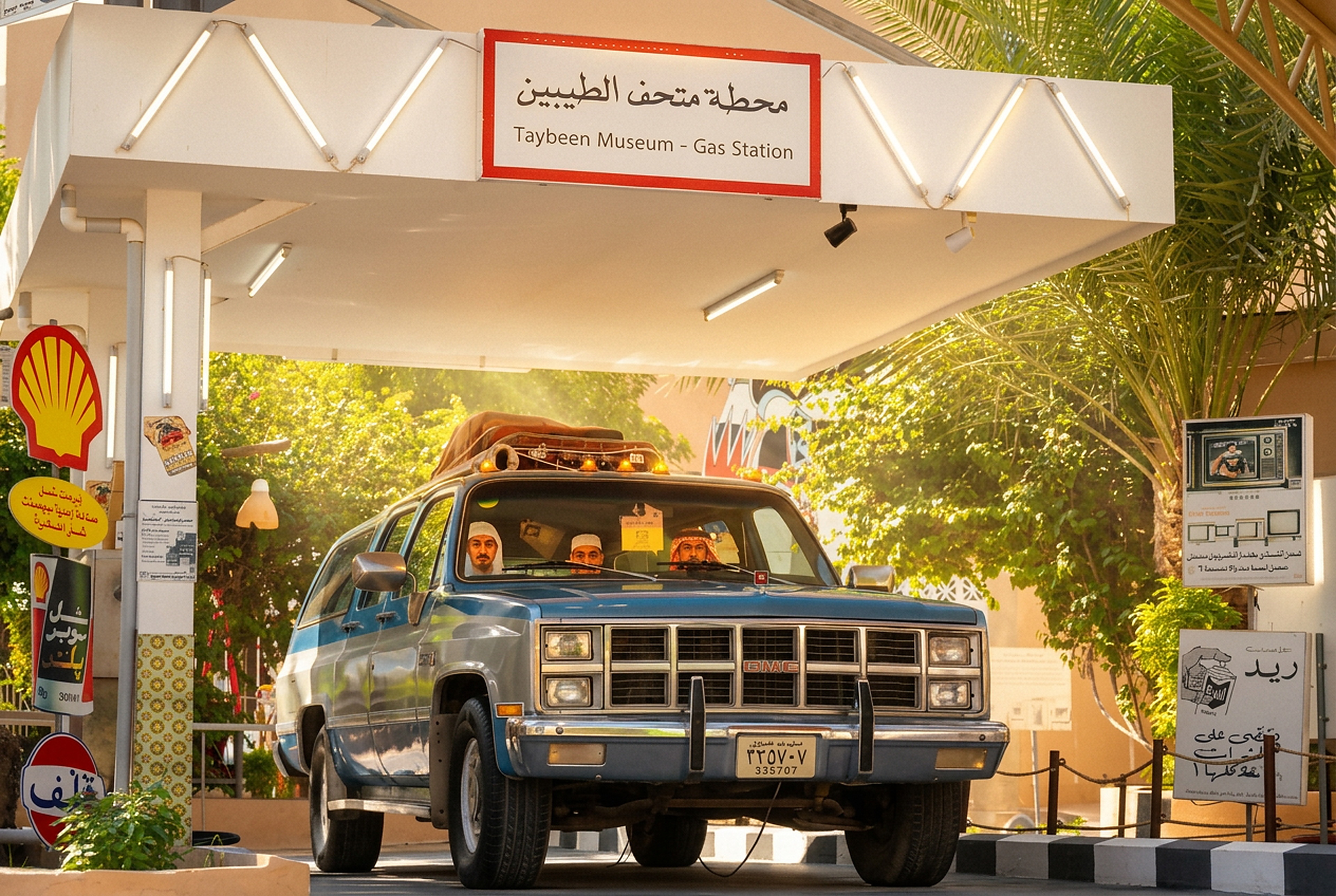 محطة الطيبين — سيارة GMC ريترو تحت مظلة المحطة القديمة بلوحة متحف الطيبين وإضاءة ذهبية حالمة